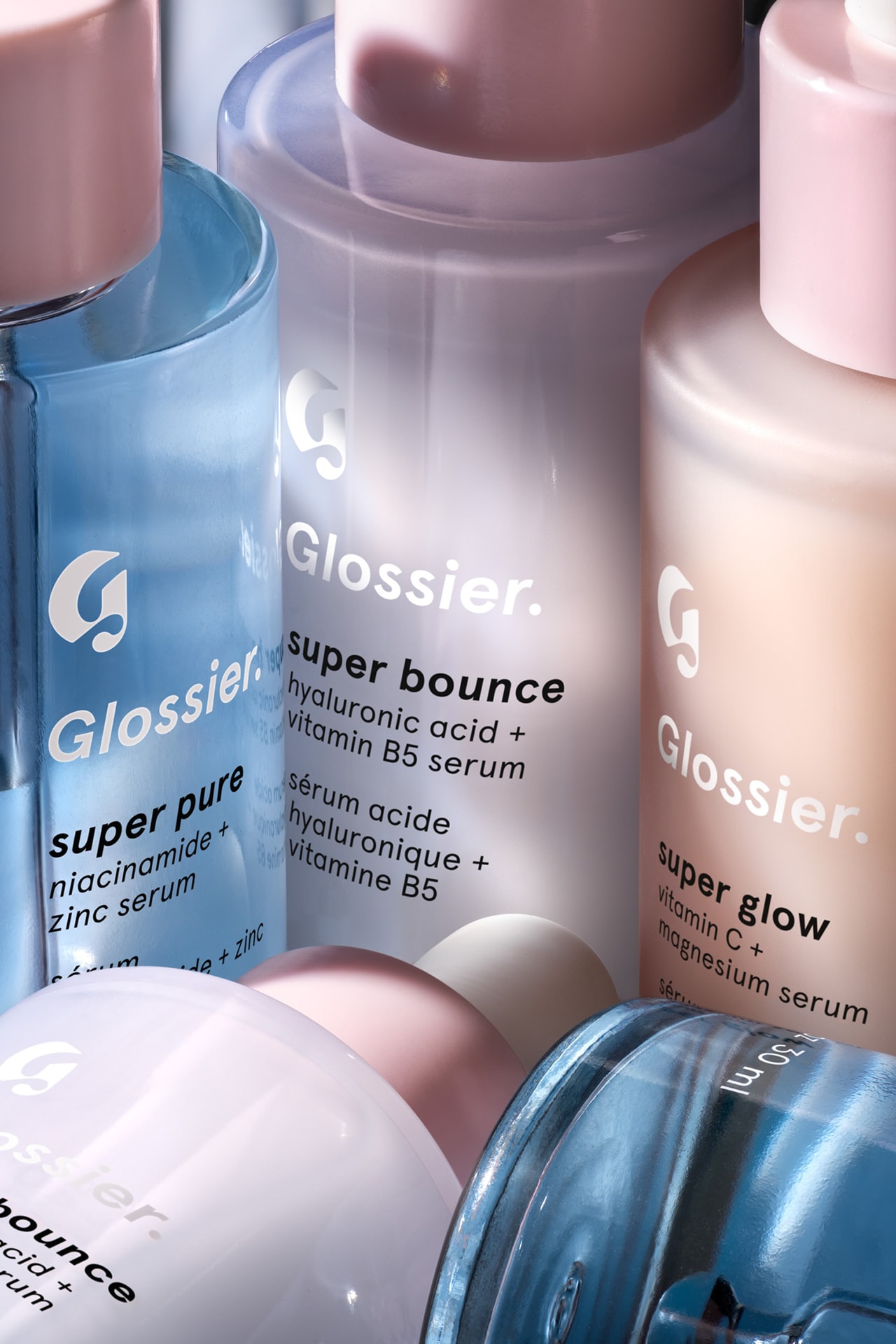 Glossier Supers Serums Super Bounce Pure Glow Bigger Bottles Packaging Beauty Skincare Emily Weiss Dropper Cosmetics Blue Purple Orange Pink