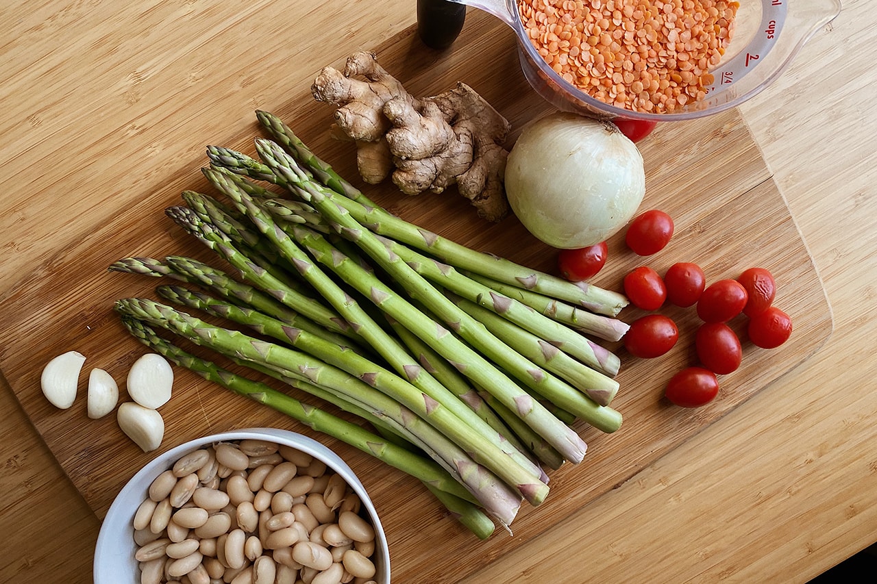 Healthy Food Ingredients Asparagus Vegetables Onion Red Lentils Ginger Garlic Beans Kitchen Table Chopping Board Wood