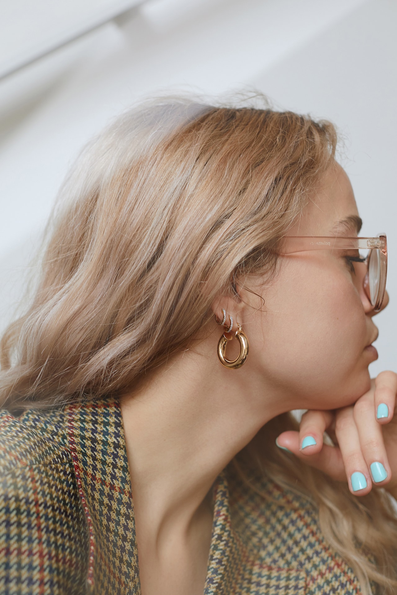 stephanie broek blonde hair glasses blue nail polish blazer earrings