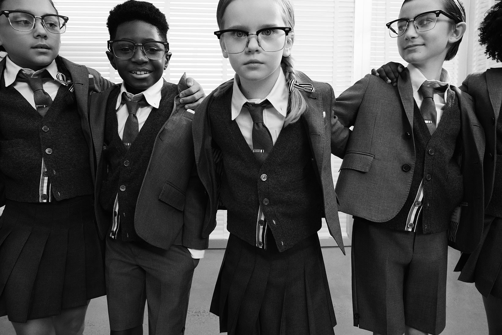 thom browne childrenswear kids line launch campaign school uniform blazers jackets pleated skirts group students glasses friends