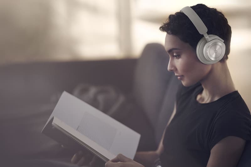 bang and olufsen beoplay hx headphones listening music sand beige reading book