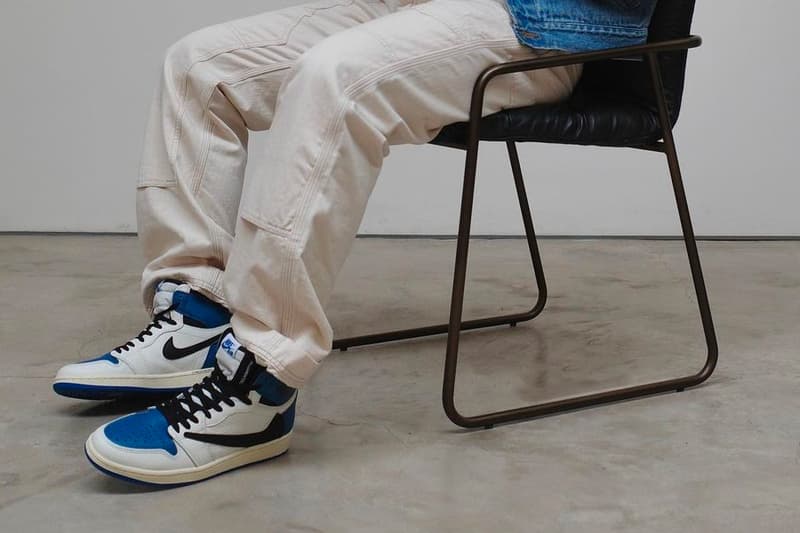 travis scott fragment design air jordan 1 aj1 high og military blue closer look chair sitting on foot trousers