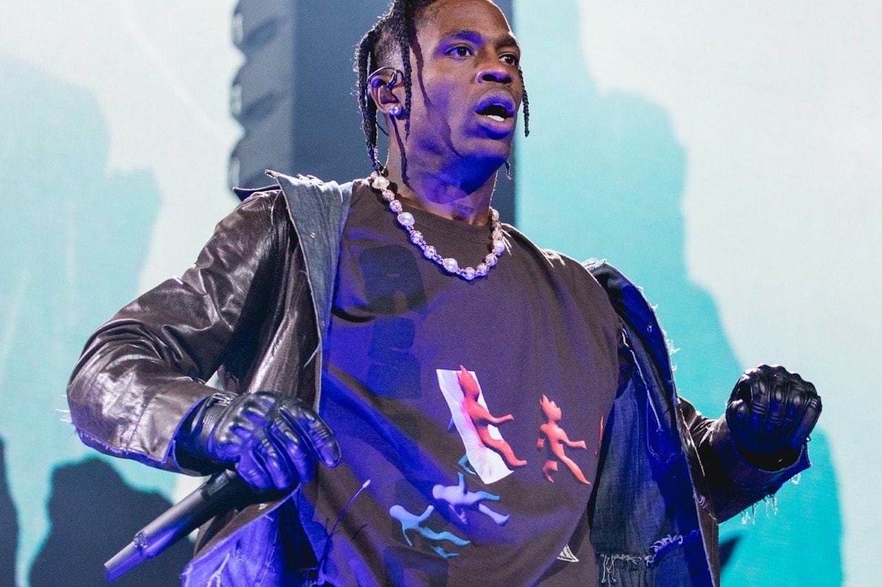 travis scott performing on stage leather outfit chain graphic tee