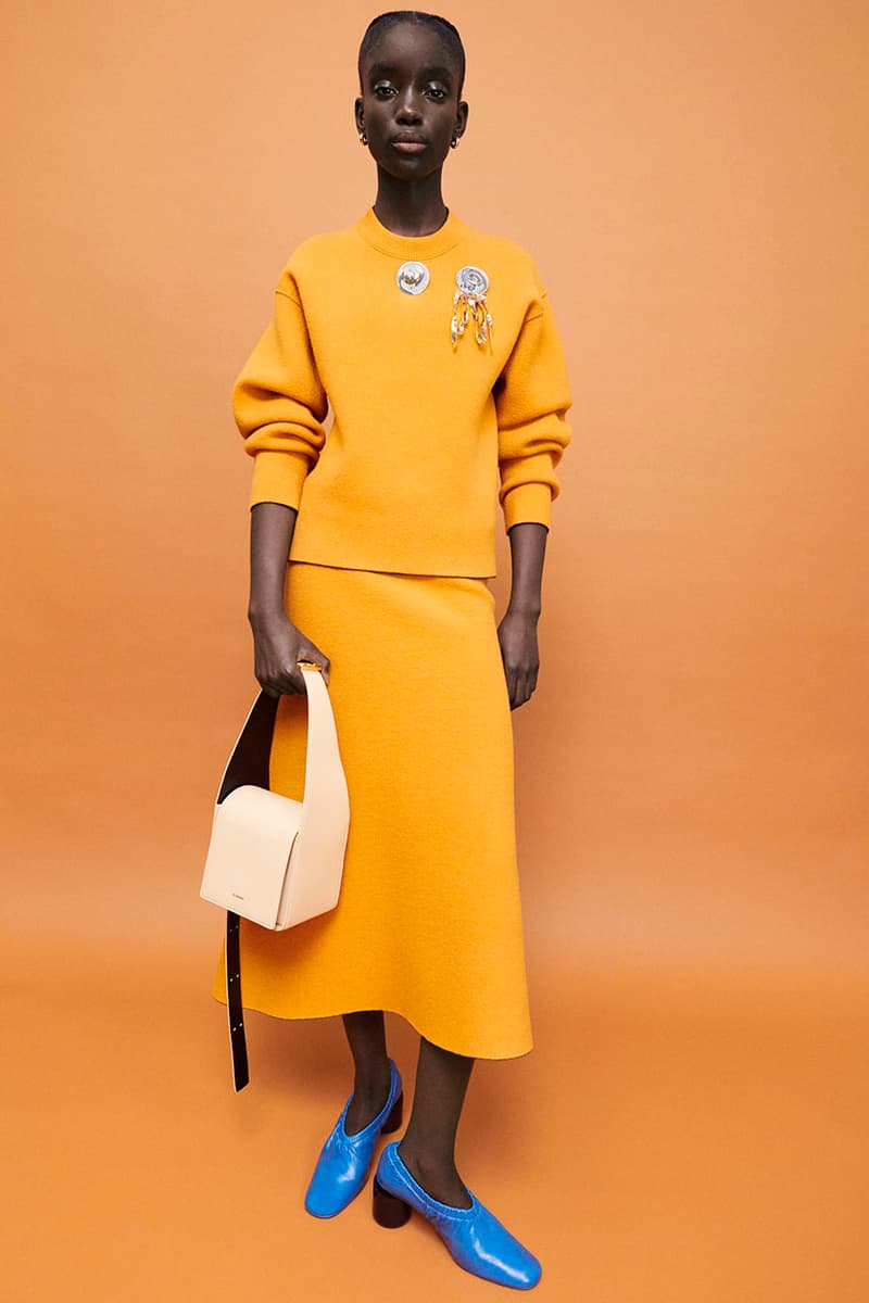 jil sander women's pre-fall 2022 collection matching orange sweater skirt blue boots white bag