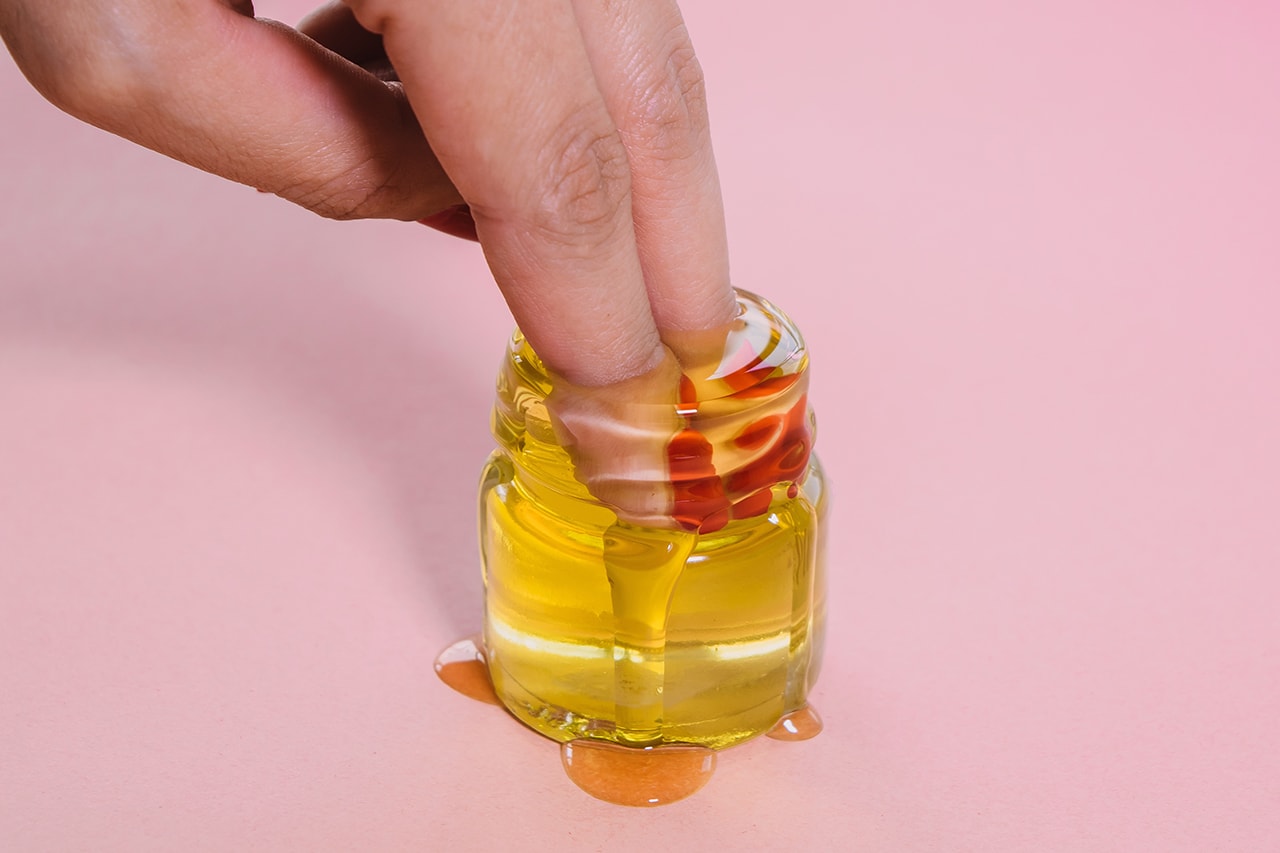 Person Putting Hand in Honey Jar