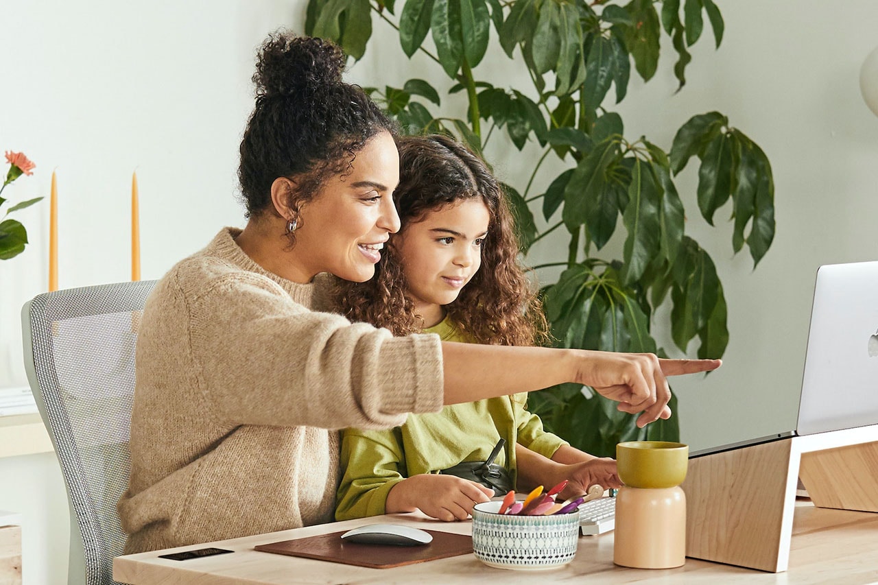 Mother teaching daughter using a computer