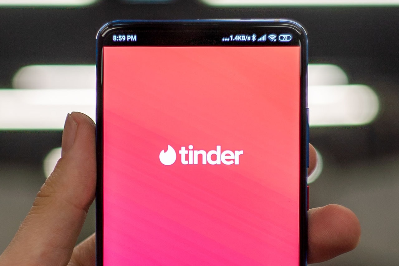 Man holding phone using Tinder dating app