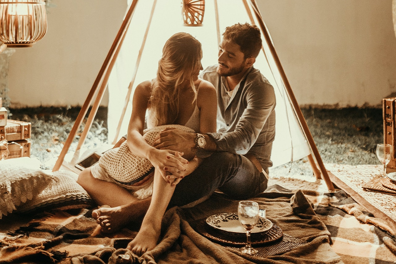 Couple sitting underneath tent and romantic lights