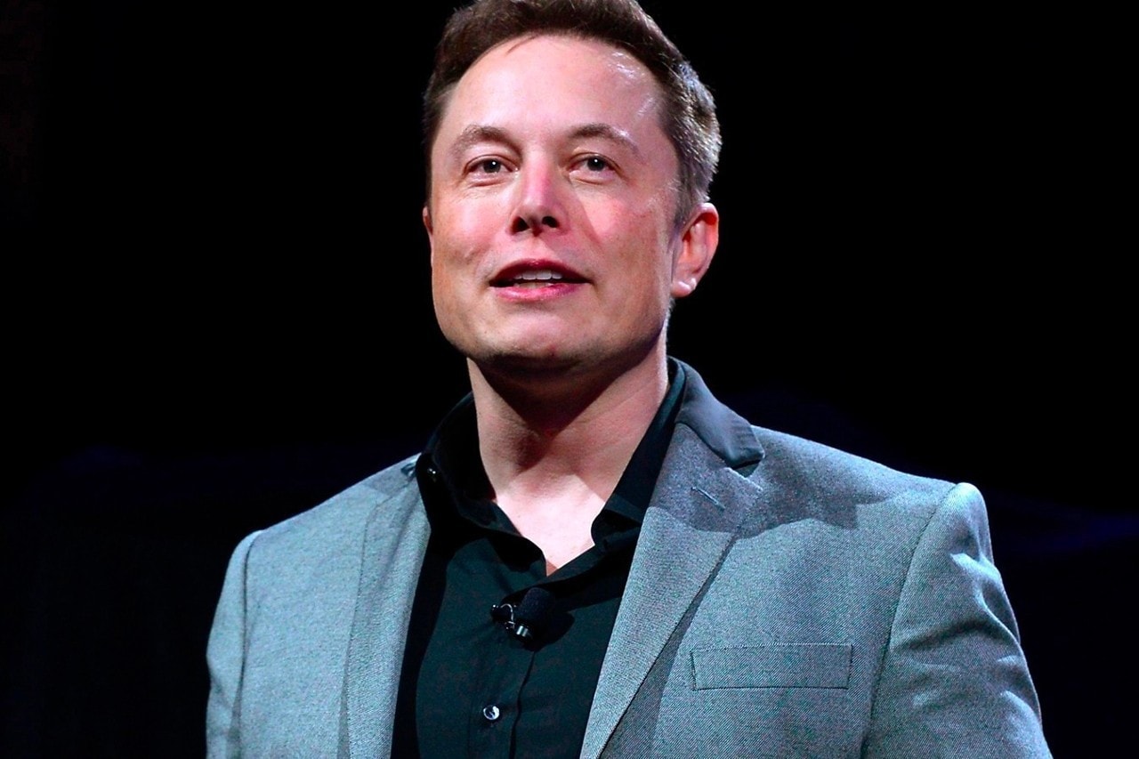 Elon Musk against black background smirking