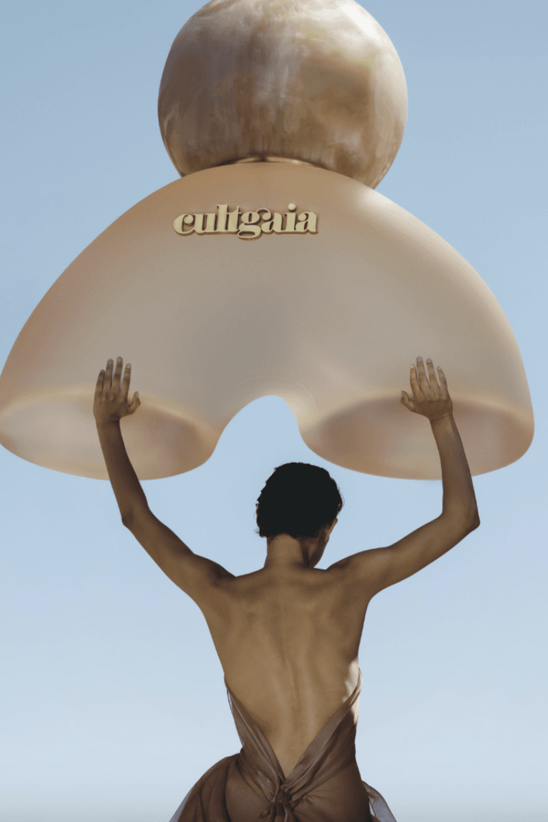 woman lying down in desert in sage colored dress, cult gaia, fragrance launch