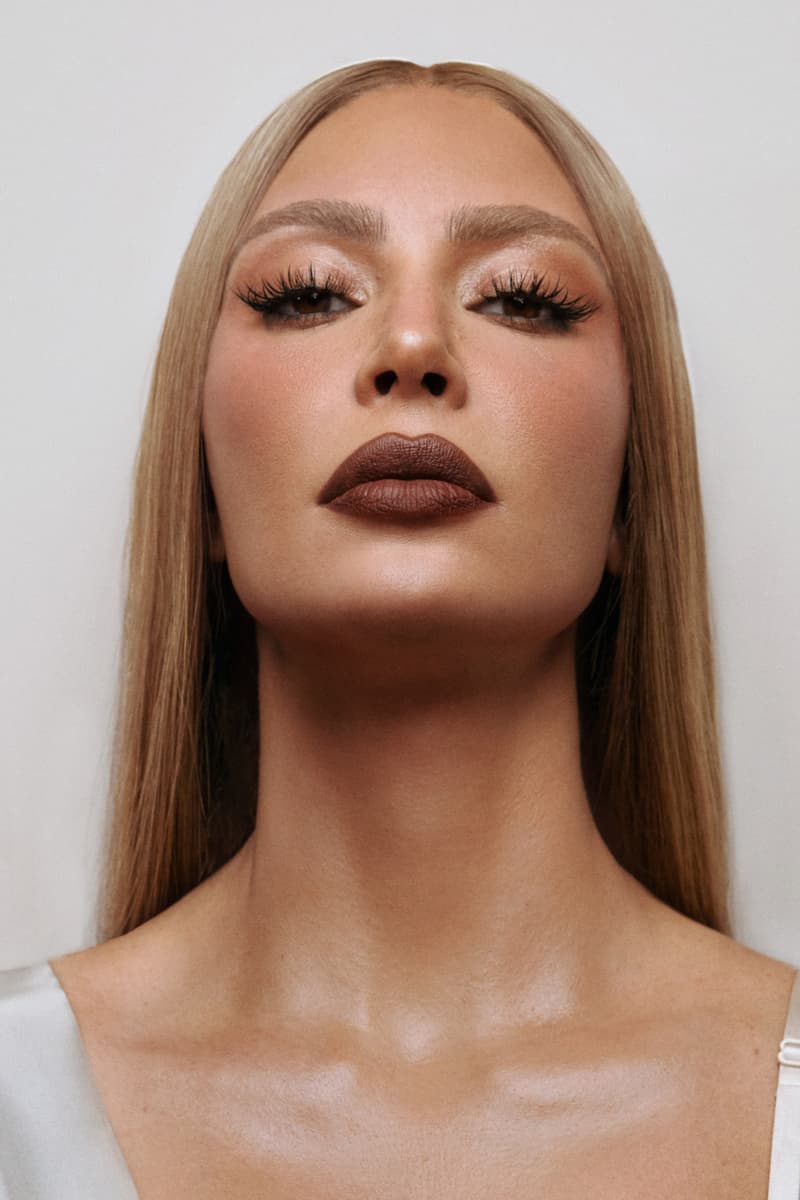 kim kardashian posing with red hair and new skkn by kim matte lipstick, makeup, skincare, kardashians