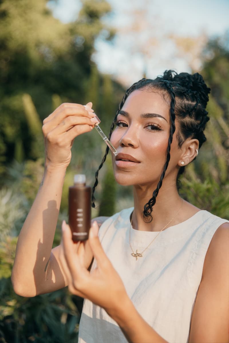 jhene aiko posing in the back of a car, skincare, cbd, body care, jhenetics