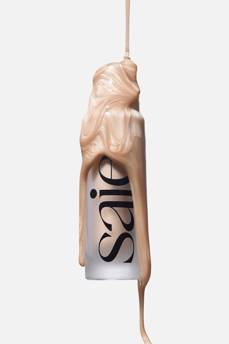 woman caressing bottle of saie beauty glowy super gel in warm glow, swatch of highlighting primer, makeup, skincare