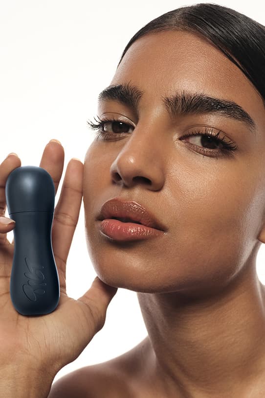 model holding tilt makeup product, accessible beauty, soriatic arthritis 