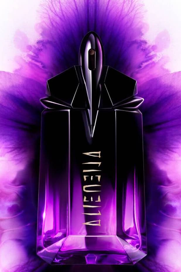 anok yai posing with a bottle of mugler alien extraintense, fragrance, perfume, beauty