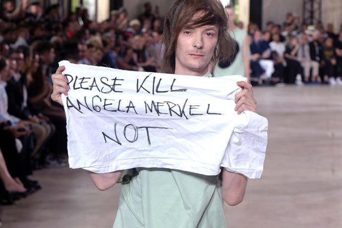 Rick Owens のショーでモデルが抗議メッセージを掲げる