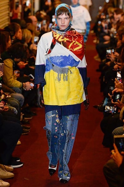 デムナワールドが炸裂した Vetements 2018年秋冬コレクション ストリート＆オーバーサイズという真骨頂の中でスカーフと壊滅的なミリタリーパンツを提案した圧巻のランウェイ パリファッションウィークの公式スケジュールから脱退した〈Vetements（ヴェトモン）〉が、レッドカーペットを敷き詰めた会場で宣言通りの単独ショーを開催した。ストリートとルーズシルエットというDemna Gvasalia（デムナ・ヴァザリア）の真骨頂の中で印象的に映るのは、スカーフの提案と壊滅的に近いミリタリーパンツのダメージ加工。落書きやワッペンの配置、多様多種な柄物のミックスからは、80年代〜90年代のヴィンテージ古着に見るカオティックな雰囲気が漂うほか、Marilyn Manson（マリリン・マンソン）のシャツなども組み込まれ、何とも形容し難いDemnaならではの世界観を構築して観衆を釘付けにした。 ちなみに、下のInstagramの動画はインビテーションであるレシートを撮影したもの。見応え満載の全57体のルックはフォトギャラリーからご確認を。 〈Vetements〉と〈Reebok（リーボック）〉によるブルーを効かせたGenetically Modified Pumpの限定カラーもお買い逃しのないように。