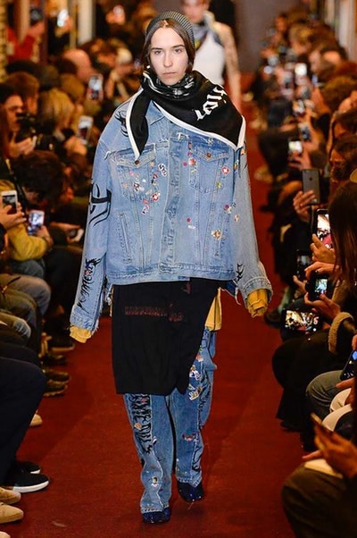 デムナワールドが炸裂した Vetements 2018年秋冬コレクション ストリート＆オーバーサイズという真骨頂の中でスカーフと壊滅的なミリタリーパンツを提案した圧巻のランウェイ パリファッションウィークの公式スケジュールから脱退した〈Vetements（ヴェトモン）〉が、レッドカーペットを敷き詰めた会場で宣言通りの単独ショーを開催した。ストリートとルーズシルエットというDemna Gvasalia（デムナ・ヴァザリア）の真骨頂の中で印象的に映るのは、スカーフの提案と壊滅的に近いミリタリーパンツのダメージ加工。落書きやワッペンの配置、多様多種な柄物のミックスからは、80年代〜90年代のヴィンテージ古着に見るカオティックな雰囲気が漂うほか、Marilyn Manson（マリリン・マンソン）のシャツなども組み込まれ、何とも形容し難いDemnaならではの世界観を構築して観衆を釘付けにした。 ちなみに、下のInstagramの動画はインビテーションであるレシートを撮影したもの。見応え満載の全57体のルックはフォトギャラリーからご確認を。 〈Vetements〉と〈Reebok（リーボック）〉によるブルーを効かせたGenetically Modified Pumpの限定カラーもお買い逃しのないように。