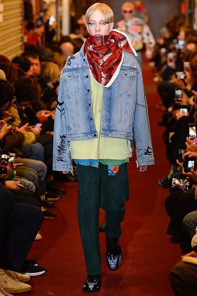 デムナワールドが炸裂した Vetements 2018年秋冬コレクション ストリート＆オーバーサイズという真骨頂の中でスカーフと壊滅的なミリタリーパンツを提案した圧巻のランウェイ パリファッションウィークの公式スケジュールから脱退した〈Vetements（ヴェトモン）〉が、レッドカーペットを敷き詰めた会場で宣言通りの単独ショーを開催した。ストリートとルーズシルエットというDemna Gvasalia（デムナ・ヴァザリア）の真骨頂の中で印象的に映るのは、スカーフの提案と壊滅的に近いミリタリーパンツのダメージ加工。落書きやワッペンの配置、多様多種な柄物のミックスからは、80年代〜90年代のヴィンテージ古着に見るカオティックな雰囲気が漂うほか、Marilyn Manson（マリリン・マンソン）のシャツなども組み込まれ、何とも形容し難いDemnaならではの世界観を構築して観衆を釘付けにした。 ちなみに、下のInstagramの動画はインビテーションであるレシートを撮影したもの。見応え満載の全57体のルックはフォトギャラリーからご確認を。 〈Vetements〉と〈Reebok（リーボック）〉によるブルーを効かせたGenetically Modified Pumpの限定カラーもお買い逃しのないように。