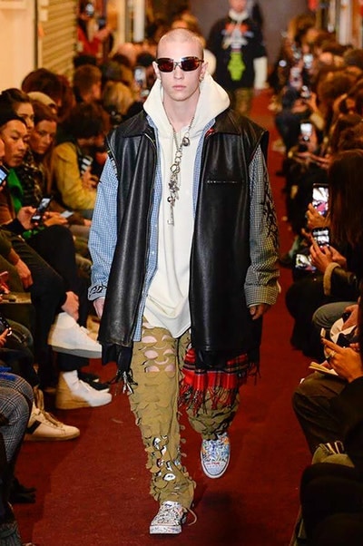 デムナワールドが炸裂した Vetements 2018年秋冬コレクション ストリート＆オーバーサイズという真骨頂の中でスカーフと壊滅的なミリタリーパンツを提案した圧巻のランウェイ パリファッションウィークの公式スケジュールから脱退した〈Vetements（ヴェトモン）〉が、レッドカーペットを敷き詰めた会場で宣言通りの単独ショーを開催した。ストリートとルーズシルエットというDemna Gvasalia（デムナ・ヴァザリア）の真骨頂の中で印象的に映るのは、スカーフの提案と壊滅的に近いミリタリーパンツのダメージ加工。落書きやワッペンの配置、多様多種な柄物のミックスからは、80年代〜90年代のヴィンテージ古着に見るカオティックな雰囲気が漂うほか、Marilyn Manson（マリリン・マンソン）のシャツなども組み込まれ、何とも形容し難いDemnaならではの世界観を構築して観衆を釘付けにした。 ちなみに、下のInstagramの動画はインビテーションであるレシートを撮影したもの。見応え満載の全57体のルックはフォトギャラリーからご確認を。 〈Vetements〉と〈Reebok（リーボック）〉によるブルーを効かせたGenetically Modified Pumpの限定カラーもお買い逃しのないように。