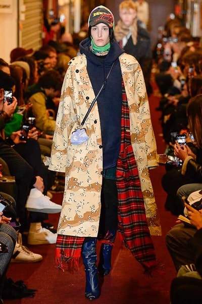デムナワールドが炸裂した Vetements 2018年秋冬コレクション ストリート＆オーバーサイズという真骨頂の中でスカーフと壊滅的なミリタリーパンツを提案した圧巻のランウェイ パリファッションウィークの公式スケジュールから脱退した〈Vetements（ヴェトモン）〉が、レッドカーペットを敷き詰めた会場で宣言通りの単独ショーを開催した。ストリートとルーズシルエットというDemna Gvasalia（デムナ・ヴァザリア）の真骨頂の中で印象的に映るのは、スカーフの提案と壊滅的に近いミリタリーパンツのダメージ加工。落書きやワッペンの配置、多様多種な柄物のミックスからは、80年代〜90年代のヴィンテージ古着に見るカオティックな雰囲気が漂うほか、Marilyn Manson（マリリン・マンソン）のシャツなども組み込まれ、何とも形容し難いDemnaならではの世界観を構築して観衆を釘付けにした。 ちなみに、下のInstagramの動画はインビテーションであるレシートを撮影したもの。見応え満載の全57体のルックはフォトギャラリーからご確認を。 〈Vetements〉と〈Reebok（リーボック）〉によるブルーを効かせたGenetically Modified Pumpの限定カラーもお買い逃しのないように。