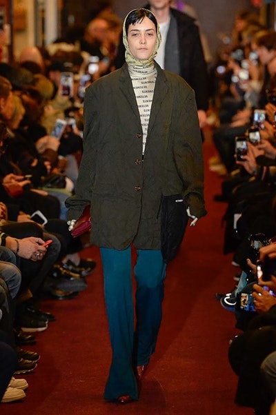 デムナワールドが炸裂した Vetements 2018年秋冬コレクション ストリート＆オーバーサイズという真骨頂の中でスカーフと壊滅的なミリタリーパンツを提案した圧巻のランウェイ パリファッションウィークの公式スケジュールから脱退した〈Vetements（ヴェトモン）〉が、レッドカーペットを敷き詰めた会場で宣言通りの単独ショーを開催した。ストリートとルーズシルエットというDemna Gvasalia（デムナ・ヴァザリア）の真骨頂の中で印象的に映るのは、スカーフの提案と壊滅的に近いミリタリーパンツのダメージ加工。落書きやワッペンの配置、多様多種な柄物のミックスからは、80年代〜90年代のヴィンテージ古着に見るカオティックな雰囲気が漂うほか、Marilyn Manson（マリリン・マンソン）のシャツなども組み込まれ、何とも形容し難いDemnaならではの世界観を構築して観衆を釘付けにした。 ちなみに、下のInstagramの動画はインビテーションであるレシートを撮影したもの。見応え満載の全57体のルックはフォトギャラリーからご確認を。 〈Vetements〉と〈Reebok（リーボック）〉によるブルーを効かせたGenetically Modified Pumpの限定カラーもお買い逃しのないように。