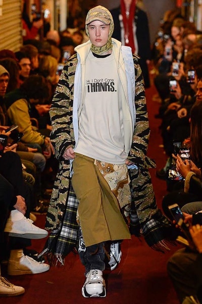 デムナワールドが炸裂した Vetements 2018年秋冬コレクション ストリート＆オーバーサイズという真骨頂の中でスカーフと壊滅的なミリタリーパンツを提案した圧巻のランウェイ パリファッションウィークの公式スケジュールから脱退した〈Vetements（ヴェトモン）〉が、レッドカーペットを敷き詰めた会場で宣言通りの単独ショーを開催した。ストリートとルーズシルエットというDemna Gvasalia（デムナ・ヴァザリア）の真骨頂の中で印象的に映るのは、スカーフの提案と壊滅的に近いミリタリーパンツのダメージ加工。落書きやワッペンの配置、多様多種な柄物のミックスからは、80年代〜90年代のヴィンテージ古着に見るカオティックな雰囲気が漂うほか、Marilyn Manson（マリリン・マンソン）のシャツなども組み込まれ、何とも形容し難いDemnaならではの世界観を構築して観衆を釘付けにした。 ちなみに、下のInstagramの動画はインビテーションであるレシートを撮影したもの。見応え満載の全57体のルックはフォトギャラリーからご確認を。 〈Vetements〉と〈Reebok（リーボック）〉によるブルーを効かせたGenetically Modified Pumpの限定カラーもお買い逃しのないように。
