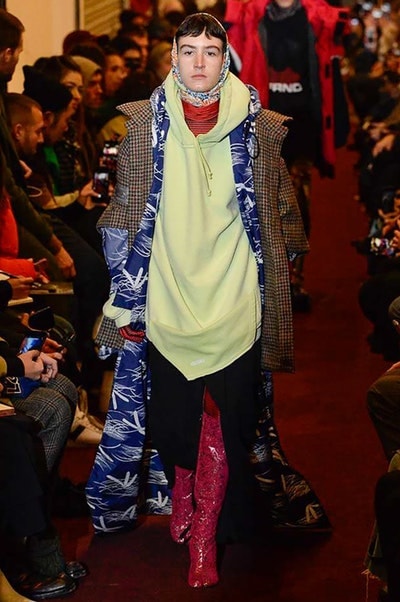 デムナワールドが炸裂した Vetements 2018年秋冬コレクション ストリート＆オーバーサイズという真骨頂の中でスカーフと壊滅的なミリタリーパンツを提案した圧巻のランウェイ パリファッションウィークの公式スケジュールから脱退した〈Vetements（ヴェトモン）〉が、レッドカーペットを敷き詰めた会場で宣言通りの単独ショーを開催した。ストリートとルーズシルエットというDemna Gvasalia（デムナ・ヴァザリア）の真骨頂の中で印象的に映るのは、スカーフの提案と壊滅的に近いミリタリーパンツのダメージ加工。落書きやワッペンの配置、多様多種な柄物のミックスからは、80年代〜90年代のヴィンテージ古着に見るカオティックな雰囲気が漂うほか、Marilyn Manson（マリリン・マンソン）のシャツなども組み込まれ、何とも形容し難いDemnaならではの世界観を構築して観衆を釘付けにした。 ちなみに、下のInstagramの動画はインビテーションであるレシートを撮影したもの。見応え満載の全57体のルックはフォトギャラリーからご確認を。 〈Vetements〉と〈Reebok（リーボック）〉によるブルーを効かせたGenetically Modified Pumpの限定カラーもお買い逃しのないように。