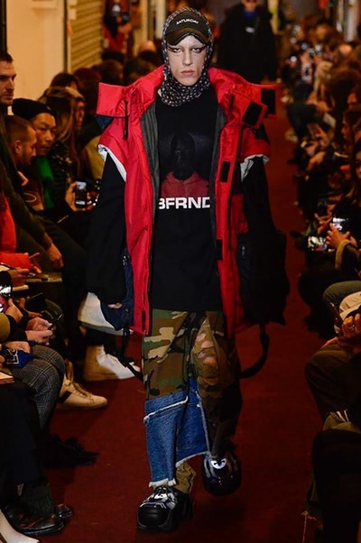 デムナワールドが炸裂した Vetements 2018年秋冬コレクション ストリート＆オーバーサイズという真骨頂の中でスカーフと壊滅的なミリタリーパンツを提案した圧巻のランウェイ パリファッションウィークの公式スケジュールから脱退した〈Vetements（ヴェトモン）〉が、レッドカーペットを敷き詰めた会場で宣言通りの単独ショーを開催した。ストリートとルーズシルエットというDemna Gvasalia（デムナ・ヴァザリア）の真骨頂の中で印象的に映るのは、スカーフの提案と壊滅的に近いミリタリーパンツのダメージ加工。落書きやワッペンの配置、多様多種な柄物のミックスからは、80年代〜90年代のヴィンテージ古着に見るカオティックな雰囲気が漂うほか、Marilyn Manson（マリリン・マンソン）のシャツなども組み込まれ、何とも形容し難いDemnaならではの世界観を構築して観衆を釘付けにした。 ちなみに、下のInstagramの動画はインビテーションであるレシートを撮影したもの。見応え満載の全57体のルックはフォトギャラリーからご確認を。 〈Vetements〉と〈Reebok（リーボック）〉によるブルーを効かせたGenetically Modified Pumpの限定カラーもお買い逃しのないように。