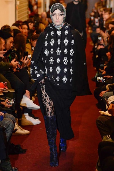 デムナワールドが炸裂した Vetements 2018年秋冬コレクション ストリート＆オーバーサイズという真骨頂の中でスカーフと壊滅的なミリタリーパンツを提案した圧巻のランウェイ パリファッションウィークの公式スケジュールから脱退した〈Vetements（ヴェトモン）〉が、レッドカーペットを敷き詰めた会場で宣言通りの単独ショーを開催した。ストリートとルーズシルエットというDemna Gvasalia（デムナ・ヴァザリア）の真骨頂の中で印象的に映るのは、スカーフの提案と壊滅的に近いミリタリーパンツのダメージ加工。落書きやワッペンの配置、多様多種な柄物のミックスからは、80年代〜90年代のヴィンテージ古着に見るカオティックな雰囲気が漂うほか、Marilyn Manson（マリリン・マンソン）のシャツなども組み込まれ、何とも形容し難いDemnaならではの世界観を構築して観衆を釘付けにした。 ちなみに、下のInstagramの動画はインビテーションであるレシートを撮影したもの。見応え満載の全57体のルックはフォトギャラリーからご確認を。 〈Vetements〉と〈Reebok（リーボック）〉によるブルーを効かせたGenetically Modified Pumpの限定カラーもお買い逃しのないように。