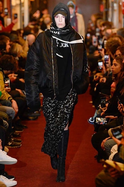 デムナワールドが炸裂した Vetements 2018年秋冬コレクション ストリート＆オーバーサイズという真骨頂の中でスカーフと壊滅的なミリタリーパンツを提案した圧巻のランウェイ パリファッションウィークの公式スケジュールから脱退した〈Vetements（ヴェトモン）〉が、レッドカーペットを敷き詰めた会場で宣言通りの単独ショーを開催した。ストリートとルーズシルエットというDemna Gvasalia（デムナ・ヴァザリア）の真骨頂の中で印象的に映るのは、スカーフの提案と壊滅的に近いミリタリーパンツのダメージ加工。落書きやワッペンの配置、多様多種な柄物のミックスからは、80年代〜90年代のヴィンテージ古着に見るカオティックな雰囲気が漂うほか、Marilyn Manson（マリリン・マンソン）のシャツなども組み込まれ、何とも形容し難いDemnaならではの世界観を構築して観衆を釘付けにした。 ちなみに、下のInstagramの動画はインビテーションであるレシートを撮影したもの。見応え満載の全57体のルックはフォトギャラリーからご確認を。 〈Vetements〉と〈Reebok（リーボック）〉によるブルーを効かせたGenetically Modified Pumpの限定カラーもお買い逃しのないように。
