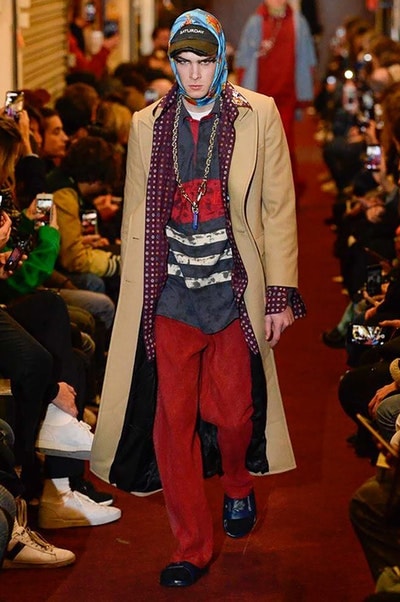 デムナワールドが炸裂した Vetements 2018年秋冬コレクション ストリート＆オーバーサイズという真骨頂の中でスカーフと壊滅的なミリタリーパンツを提案した圧巻のランウェイ パリファッションウィークの公式スケジュールから脱退した〈Vetements（ヴェトモン）〉が、レッドカーペットを敷き詰めた会場で宣言通りの単独ショーを開催した。ストリートとルーズシルエットというDemna Gvasalia（デムナ・ヴァザリア）の真骨頂の中で印象的に映るのは、スカーフの提案と壊滅的に近いミリタリーパンツのダメージ加工。落書きやワッペンの配置、多様多種な柄物のミックスからは、80年代〜90年代のヴィンテージ古着に見るカオティックな雰囲気が漂うほか、Marilyn Manson（マリリン・マンソン）のシャツなども組み込まれ、何とも形容し難いDemnaならではの世界観を構築して観衆を釘付けにした。 ちなみに、下のInstagramの動画はインビテーションであるレシートを撮影したもの。見応え満載の全57体のルックはフォトギャラリーからご確認を。 〈Vetements〉と〈Reebok（リーボック）〉によるブルーを効かせたGenetically Modified Pumpの限定カラーもお買い逃しのないように。