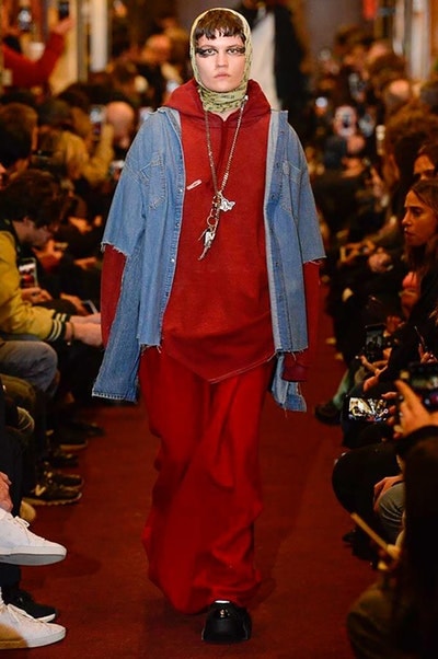 デムナワールドが炸裂した Vetements 2018年秋冬コレクション ストリート＆オーバーサイズという真骨頂の中でスカーフと壊滅的なミリタリーパンツを提案した圧巻のランウェイ パリファッションウィークの公式スケジュールから脱退した〈Vetements（ヴェトモン）〉が、レッドカーペットを敷き詰めた会場で宣言通りの単独ショーを開催した。ストリートとルーズシルエットというDemna Gvasalia（デムナ・ヴァザリア）の真骨頂の中で印象的に映るのは、スカーフの提案と壊滅的に近いミリタリーパンツのダメージ加工。落書きやワッペンの配置、多様多種な柄物のミックスからは、80年代〜90年代のヴィンテージ古着に見るカオティックな雰囲気が漂うほか、Marilyn Manson（マリリン・マンソン）のシャツなども組み込まれ、何とも形容し難いDemnaならではの世界観を構築して観衆を釘付けにした。 ちなみに、下のInstagramの動画はインビテーションであるレシートを撮影したもの。見応え満載の全57体のルックはフォトギャラリーからご確認を。 〈Vetements〉と〈Reebok（リーボック）〉によるブルーを効かせたGenetically Modified Pumpの限定カラーもお買い逃しのないように。