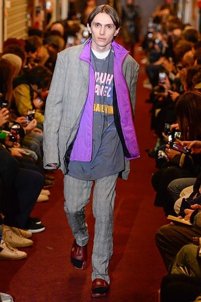 デムナワールドが炸裂した Vetements 2018年秋冬コレクション ストリート＆オーバーサイズという真骨頂の中でスカーフと壊滅的なミリタリーパンツを提案した圧巻のランウェイ パリファッションウィークの公式スケジュールから脱退した〈Vetements（ヴェトモン）〉が、レッドカーペットを敷き詰めた会場で宣言通りの単独ショーを開催した。ストリートとルーズシルエットというDemna Gvasalia（デムナ・ヴァザリア）の真骨頂の中で印象的に映るのは、スカーフの提案と壊滅的に近いミリタリーパンツのダメージ加工。落書きやワッペンの配置、多様多種な柄物のミックスからは、80年代〜90年代のヴィンテージ古着に見るカオティックな雰囲気が漂うほか、Marilyn Manson（マリリン・マンソン）のシャツなども組み込まれ、何とも形容し難いDemnaならではの世界観を構築して観衆を釘付けにした。 ちなみに、下のInstagramの動画はインビテーションであるレシートを撮影したもの。見応え満載の全57体のルックはフォトギャラリーからご確認を。 〈Vetements〉と〈Reebok（リーボック）〉によるブルーを効かせたGenetically Modified Pumpの限定カラーもお買い逃しのないように。