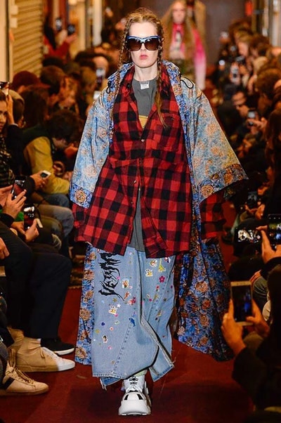 デムナワールドが炸裂した Vetements 2018年秋冬コレクション ストリート＆オーバーサイズという真骨頂の中でスカーフと壊滅的なミリタリーパンツを提案した圧巻のランウェイ パリファッションウィークの公式スケジュールから脱退した〈Vetements（ヴェトモン）〉が、レッドカーペットを敷き詰めた会場で宣言通りの単独ショーを開催した。ストリートとルーズシルエットというDemna Gvasalia（デムナ・ヴァザリア）の真骨頂の中で印象的に映るのは、スカーフの提案と壊滅的に近いミリタリーパンツのダメージ加工。落書きやワッペンの配置、多様多種な柄物のミックスからは、80年代〜90年代のヴィンテージ古着に見るカオティックな雰囲気が漂うほか、Marilyn Manson（マリリン・マンソン）のシャツなども組み込まれ、何とも形容し難いDemnaならではの世界観を構築して観衆を釘付けにした。 ちなみに、下のInstagramの動画はインビテーションであるレシートを撮影したもの。見応え満載の全57体のルックはフォトギャラリーからご確認を。 〈Vetements〉と〈Reebok（リーボック）〉によるブルーを効かせたGenetically Modified Pumpの限定カラーもお買い逃しのないように。