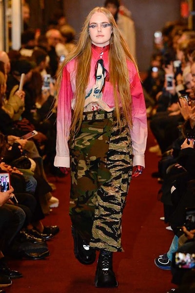 デムナワールドが炸裂した Vetements 2018年秋冬コレクション ストリート＆オーバーサイズという真骨頂の中でスカーフと壊滅的なミリタリーパンツを提案した圧巻のランウェイ パリファッションウィークの公式スケジュールから脱退した〈Vetements（ヴェトモン）〉が、レッドカーペットを敷き詰めた会場で宣言通りの単独ショーを開催した。ストリートとルーズシルエットというDemna Gvasalia（デムナ・ヴァザリア）の真骨頂の中で印象的に映るのは、スカーフの提案と壊滅的に近いミリタリーパンツのダメージ加工。落書きやワッペンの配置、多様多種な柄物のミックスからは、80年代〜90年代のヴィンテージ古着に見るカオティックな雰囲気が漂うほか、Marilyn Manson（マリリン・マンソン）のシャツなども組み込まれ、何とも形容し難いDemnaならではの世界観を構築して観衆を釘付けにした。 ちなみに、下のInstagramの動画はインビテーションであるレシートを撮影したもの。見応え満載の全57体のルックはフォトギャラリーからご確認を。 〈Vetements〉と〈Reebok（リーボック）〉によるブルーを効かせたGenetically Modified Pumpの限定カラーもお買い逃しのないように。