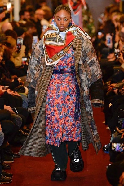 デムナワールドが炸裂した Vetements 2018年秋冬コレクション ストリート＆オーバーサイズという真骨頂の中でスカーフと壊滅的なミリタリーパンツを提案した圧巻のランウェイ パリファッションウィークの公式スケジュールから脱退した〈Vetements（ヴェトモン）〉が、レッドカーペットを敷き詰めた会場で宣言通りの単独ショーを開催した。ストリートとルーズシルエットというDemna Gvasalia（デムナ・ヴァザリア）の真骨頂の中で印象的に映るのは、スカーフの提案と壊滅的に近いミリタリーパンツのダメージ加工。落書きやワッペンの配置、多様多種な柄物のミックスからは、80年代〜90年代のヴィンテージ古着に見るカオティックな雰囲気が漂うほか、Marilyn Manson（マリリン・マンソン）のシャツなども組み込まれ、何とも形容し難いDemnaならではの世界観を構築して観衆を釘付けにした。 ちなみに、下のInstagramの動画はインビテーションであるレシートを撮影したもの。見応え満載の全57体のルックはフォトギャラリーからご確認を。 〈Vetements〉と〈Reebok（リーボック）〉によるブルーを効かせたGenetically Modified Pumpの限定カラーもお買い逃しのないように。