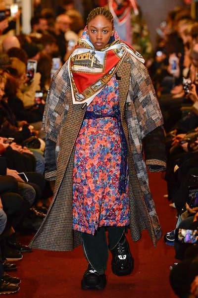 デムナワールドが炸裂した Vetements 2018年秋冬コレクション ストリート&オーバーサイズという真骨頂の中でスカーフと壊滅的なミリタリーパンツを提案した圧巻のランウェイ パリファッションウィークの公式スケジュールから脱退した〈Vetements(ヴェトモン)〉が、レッドカーペットを敷き詰めた会場で宣言通りの単独ショーを開催した。ストリートとルーズシルエットというDemna Gvasalia(デムナ・ヴァザリア)の真骨頂の中で印象的に映るのは、スカーフの提案と壊滅的に近いミリタリーパンツのダメージ加工。落書きやワッペンの配置、多様多種な柄物のミックスからは、80年代〜90年代のヴィンテージ古着に見るカオティックな雰囲気が漂うほか、Marilyn Manson(マリリン・マンソン)のシャツなども組み込まれ、何とも形容し難いDemnaならではの世界観を構築して観衆を釘付けにした。 ちなみに、下のInstagramの動画はインビテーションであるレシートを撮影したもの。見応え満載の全57体のルックはフォトギャラリーからご確認を。 〈Vetements〉と〈Reebok(リーボック)〉によるブルーを効かせたGenetically Modified Pumpの限定カラーもお買い逃しのないように。