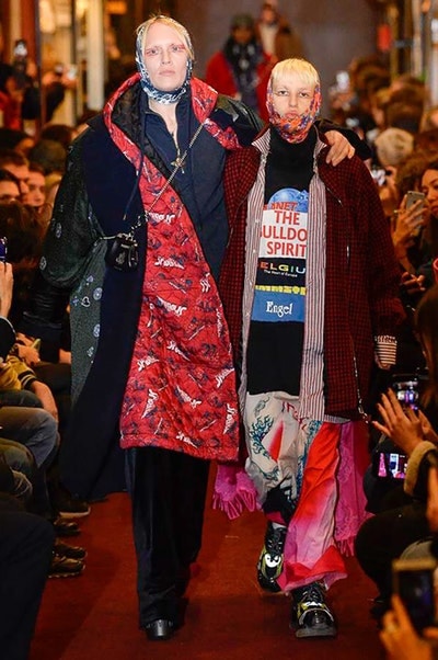 デムナワールドが炸裂した Vetements 2018年秋冬コレクション ストリート＆オーバーサイズという真骨頂の中でスカーフと壊滅的なミリタリーパンツを提案した圧巻のランウェイ パリファッションウィークの公式スケジュールから脱退した〈Vetements（ヴェトモン）〉が、レッドカーペットを敷き詰めた会場で宣言通りの単独ショーを開催した。ストリートとルーズシルエットというDemna Gvasalia（デムナ・ヴァザリア）の真骨頂の中で印象的に映るのは、スカーフの提案と壊滅的に近いミリタリーパンツのダメージ加工。落書きやワッペンの配置、多様多種な柄物のミックスからは、80年代〜90年代のヴィンテージ古着に見るカオティックな雰囲気が漂うほか、Marilyn Manson（マリリン・マンソン）のシャツなども組み込まれ、何とも形容し難いDemnaならではの世界観を構築して観衆を釘付けにした。 ちなみに、下のInstagramの動画はインビテーションであるレシートを撮影したもの。見応え満載の全57体のルックはフォトギャラリーからご確認を。 〈Vetements〉と〈Reebok（リーボック）〉によるブルーを効かせたGenetically Modified Pumpの限定カラーもお買い逃しのないように。