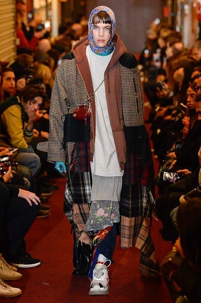 デムナワールドが炸裂した Vetements 2018年秋冬コレクション ストリート＆オーバーサイズという真骨頂の中でスカーフと壊滅的なミリタリーパンツを提案した圧巻のランウェイ パリファッションウィークの公式スケジュールから脱退した〈Vetements（ヴェトモン）〉が、レッドカーペットを敷き詰めた会場で宣言通りの単独ショーを開催した。ストリートとルーズシルエットというDemna Gvasalia（デムナ・ヴァザリア）の真骨頂の中で印象的に映るのは、スカーフの提案と壊滅的に近いミリタリーパンツのダメージ加工。落書きやワッペンの配置、多様多種な柄物のミックスからは、80年代〜90年代のヴィンテージ古着に見るカオティックな雰囲気が漂うほか、Marilyn Manson（マリリン・マンソン）のシャツなども組み込まれ、何とも形容し難いDemnaならではの世界観を構築して観衆を釘付けにした。 ちなみに、下のInstagramの動画はインビテーションであるレシートを撮影したもの。見応え満載の全57体のルックはフォトギャラリーからご確認を。 〈Vetements〉と〈Reebok（リーボック）〉によるブルーを効かせたGenetically Modified Pumpの限定カラーもお買い逃しのないように。