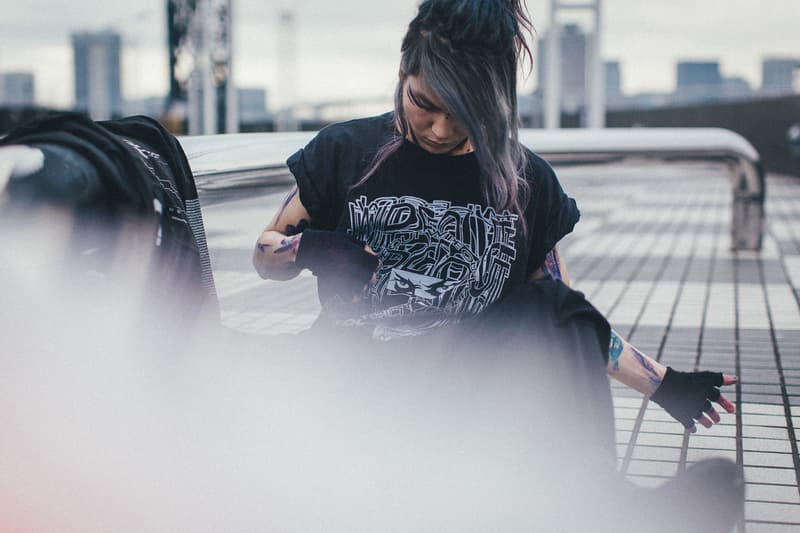 Crossfaith より2018年最初のマーチコレクションを紐解くルックブックが到着 仮想未来における“テクノロジー”にフォーカすると同時に、そこから生まれる人間の危機に警鐘を鳴らしたストリートレーベル顔負けのアイテムが登場 音楽とファッションはいつの時代も切っても切れない関係にある。しかし、最近ではマーチ(マーチャンダイジング)文化が急速に発展しており、各アーティストたちはアパレルでもアイデンティティを表現するようになった。とは言うものの、それには依然善し悪しがあるのもまた事実。だが、Crossfaith(クロスフェイス)はストリートシーンを追い続ける『HYPEBEAST』が唯一継続的にマーチを紹介する日本生まれのバンドである。 最新コレクションでは、Crossfaithが長年テーマに掲げてきた“未来”をさらに推し進め、仮想未来における“テクノロジー”にフォーカス。また、そこから生まれる人間の危機に警鐘を鳴らす形をとっているが、その中でもM-51には、CrossfaithのマーチをディレクションするHiroの考えが色濃く表現されている。本作は人類が六世紀以上前に絶滅した世界という設定の中で、その絶滅した人類の存在の調査のため火山灰に覆われた地球に降り立ち、使われた酸素濃度移行調査機とその調査員の述懐をテーマに、“Plastic Human”いうキーワードが背景に存在する。一見ネガティブに捉えられがちだが、そこには人間の可能性への問いかけがあり、希望があるのだ。 Hiroを含め、Crossfaithは今、環境的な教育へと目を向けており、人が見ない、もしくは怖いという感情から見ようとしない闇の部分にいち早く触れて、認識、そしてそれに伴う行動をとっていきたいと語る。彼らはファッションブランドではない。だからこそ、筆者としてはこれを1つのクリエイションとして捉え、今まで以上にCrossfaithの音楽と動向に期待していくべきだと感じている。ストリートレーベル顔負けのグラフィカルなアイテムは、オンラインストアでも一部購入することが可能なので、気になる方はオンラインストアを覗いてみてはいかがだろうか。