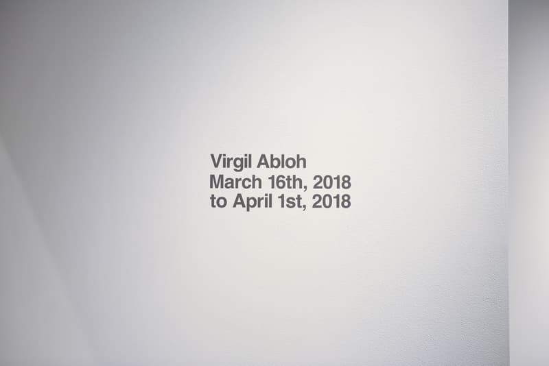 ヴァージル・アブロー初の個展 “PAY PER VIEW” に潜入 メディアや広告に踊らされ、消費によって形作られる現代社会へ向けた異才からのメッセージを体感せよ 良くも悪くもメディアや広告に踊らされ、消費によって形作られる現代社会へ向けた異才からのメッセージ 3月16日(金)より、『Kaikai Kiki Gallery』ではVirgil Abloh(ヴァージル・アブロー)の個展“PAY PER VIEW”が開催されている。「俺たちは全員、消費という行為によって形作られている」、そんなキャッチコピーを掲げる本展では、メディアが人類による世界の見方にいかに重大な影響を与えているのかを示すものだ。 ひとつめの部屋の中央には、モーターレース「NASCAR(ナスカー)」の公式スポンサーである石油会社「SUNOCO(スノコ)」の脚の折れたガソリンスタンド看板が鎮座。また、そのアートピースを背にした正面には、「“ADVERTISE HERE”」の文字が書かれたキャンバスが設置されているが、その下に添えられている電話番号「+1-855-633-9483」はVirgil本人のTwitterにも記載があり、実際にここに電話をかけると〈Off-White™️(オフホワイト)〉のデザイナーが2016年春のコレクション“Blue Collar”の説明をしてくれるのだ。また、ローラーなどは一切使用せず、黒い油絵具と画筆で塗り潰された3,000cm x 1,000cmのキャンバスは、戦前に抽象絵画を手掛けた最初の人物、Kasimir Malevich(カジミール・マレーヴィチ)の作品「黒の正方形」にインスパイアされている。美術史に大きな足跡を残し、存在論や認識論など様々な角度から分析されたこの名画は、視覚的刺激や意味をなすものを排除した完全なる抽象画であるが、Virgilが一人で描き上げたキャンバスの下には、「JCDecaux(ジーセードコー)」、「OUTFRONT(アウトフロント)」、「LAMAR(ラマー)」といった広告企業のロゴが配置。VirgilはMalevichの対話のルールを使って線と線をつなぎ、鑑賞者は広告が持つ力を突き詰めて蒸留したところに残る核心である、という内在的な意図を解き明かしているのだ。 一方、奥の部屋は床一面が畳に。中央に置かれたサイネージに流れてるのは、バルセロナで撮影した〈Off-White™️〉のコレクションムービーだが、「Coca-Cola(コカ・コーラ)」、「DASANI(ダサニ)」、「Perrier(ペリエ)」など、世界的知名度を持つ飲料のロゴを表示するアナログな作品と、スプレーペイントを施した4枚綴りのキャンバスが同居することにより、言葉にしがたい不思議な感覚に陥る空間のミスマッチが生じている。 “PAY PER VIEW”の展示の様子は上のフォトギャラリーよりご確認いただけるが、作品を俯瞰で捉え、感覚を研ぎ澄ますことで伝わってくるVirgilのメッセージはこの空間でしか感じることができない。以下の会期とご自身のスケジュールを照らし合わせ、是非『Kaikai Kiki Gallery』まで足を運んでみてはいかがだろうか。 Virgil Abloh “PAY PER VIEW” @ Kaikai Kiki Gallery 住所:東京都港区元麻布2-3-30 元麻布クレストビルB1 会期:2018年3月16日(金)〜4月1日(日) 時間:11:00 – 19:00 休館日:日、月、祝(最終日の4月1日のみ日曜営業)