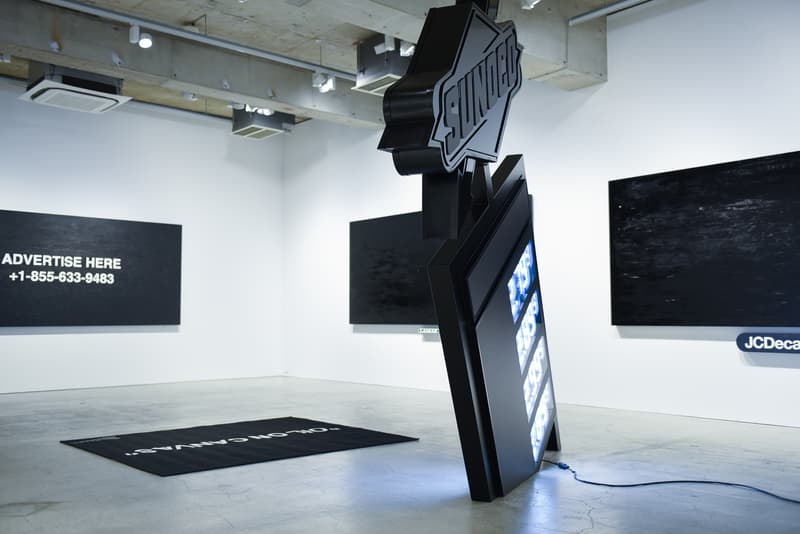 ヴァージル・アブロー初の個展 “PAY PER VIEW” に潜入 メディアや広告に踊らされ、消費によって形作られる現代社会へ向けた異才からのメッセージを体感せよ 良くも悪くもメディアや広告に踊らされ、消費によって形作られる現代社会へ向けた異才からのメッセージ 3月16日(金)より、『Kaikai Kiki Gallery』ではVirgil Abloh(ヴァージル・アブロー)の個展“PAY PER VIEW”が開催されている。「俺たちは全員、消費という行為によって形作られている」、そんなキャッチコピーを掲げる本展では、メディアが人類による世界の見方にいかに重大な影響を与えているのかを示すものだ。 ひとつめの部屋の中央には、モーターレース「NASCAR(ナスカー)」の公式スポンサーである石油会社「SUNOCO(スノコ)」の脚の折れたガソリンスタンド看板が鎮座。また、そのアートピースを背にした正面には、「“ADVERTISE HERE”」の文字が書かれたキャンバスが設置されているが、その下に添えられている電話番号「+1-855-633-9483」はVirgil本人のTwitterにも記載があり、実際にここに電話をかけると〈Off-White™️(オフホワイト)〉のデザイナーが2016年春のコレクション“Blue Collar”の説明をしてくれるのだ。また、ローラーなどは一切使用せず、黒い油絵具と画筆で塗り潰された3,000cm x 1,000cmのキャンバスは、戦前に抽象絵画を手掛けた最初の人物、Kasimir Malevich(カジミール・マレーヴィチ)の作品「黒の正方形」にインスパイアされている。美術史に大きな足跡を残し、存在論や認識論など様々な角度から分析されたこの名画は、視覚的刺激や意味をなすものを排除した完全なる抽象画であるが、Virgilが一人で描き上げたキャンバスの下には、「JCDecaux(ジーセードコー)」、「OUTFRONT(アウトフロント)」、「LAMAR(ラマー)」といった広告企業のロゴが配置。VirgilはMalevichの対話のルールを使って線と線をつなぎ、鑑賞者は広告が持つ力を突き詰めて蒸留したところに残る核心である、という内在的な意図を解き明かしているのだ。 一方、奥の部屋は床一面が畳に。中央に置かれたサイネージに流れてるのは、バルセロナで撮影した〈Off-White™️〉のコレクションムービーだが、「Coca-Cola(コカ・コーラ)」、「DASANI(ダサニ)」、「Perrier(ペリエ)」など、世界的知名度を持つ飲料のロゴを表示するアナログな作品と、スプレーペイントを施した4枚綴りのキャンバスが同居することにより、言葉にしがたい不思議な感覚に陥る空間のミスマッチが生じている。 “PAY PER VIEW”の展示の様子は上のフォトギャラリーよりご確認いただけるが、作品を俯瞰で捉え、感覚を研ぎ澄ますことで伝わってくるVirgilのメッセージはこの空間でしか感じることができない。以下の会期とご自身のスケジュールを照らし合わせ、是非『Kaikai Kiki Gallery』まで足を運んでみてはいかがだろうか。 Virgil Abloh “PAY PER VIEW” @ Kaikai Kiki Gallery 住所:東京都港区元麻布2-3-30 元麻布クレストビルB1 会期:2018年3月16日(金)〜4月1日(日) 時間:11:00 – 19:00 休館日:日、月、祝(最終日の4月1日のみ日曜営業)