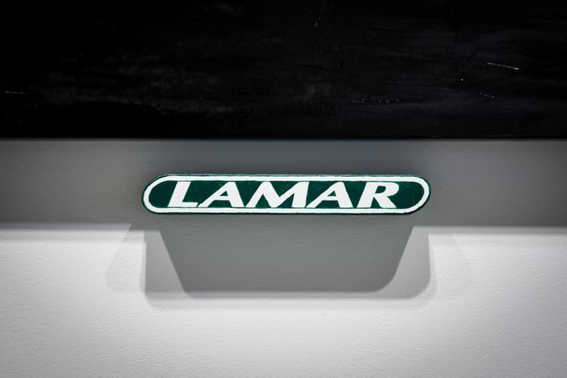 ヴァージル・アブロー初の個展 “PAY PER VIEW” に潜入 メディアや広告に踊らされ、消費によって形作られる現代社会へ向けた異才からのメッセージを体感せよ 良くも悪くもメディアや広告に踊らされ、消費によって形作られる現代社会へ向けた異才からのメッセージ 3月16日(金)より、『Kaikai Kiki Gallery』ではVirgil Abloh(ヴァージル・アブロー)の個展“PAY PER VIEW”が開催されている。「俺たちは全員、消費という行為によって形作られている」、そんなキャッチコピーを掲げる本展では、メディアが人類による世界の見方にいかに重大な影響を与えているのかを示すものだ。 ひとつめの部屋の中央には、モーターレース「NASCAR(ナスカー)」の公式スポンサーである石油会社「SUNOCO(スノコ)」の脚の折れたガソリンスタンド看板が鎮座。また、そのアートピースを背にした正面には、「“ADVERTISE HERE”」の文字が書かれたキャンバスが設置されているが、その下に添えられている電話番号「+1-855-633-9483」はVirgil本人のTwitterにも記載があり、実際にここに電話をかけると〈Off-White™️(オフホワイト)〉のデザイナーが2016年春のコレクション“Blue Collar”の説明をしてくれるのだ。また、ローラーなどは一切使用せず、黒い油絵具と画筆で塗り潰された3,000cm x 1,000cmのキャンバスは、戦前に抽象絵画を手掛けた最初の人物、Kasimir Malevich(カジミール・マレーヴィチ)の作品「黒の正方形」にインスパイアされている。美術史に大きな足跡を残し、存在論や認識論など様々な角度から分析されたこの名画は、視覚的刺激や意味をなすものを排除した完全なる抽象画であるが、Virgilが一人で描き上げたキャンバスの下には、「JCDecaux(ジーセードコー)」、「OUTFRONT(アウトフロント)」、「LAMAR(ラマー)」といった広告企業のロゴが配置。VirgilはMalevichの対話のルールを使って線と線をつなぎ、鑑賞者は広告が持つ力を突き詰めて蒸留したところに残る核心である、という内在的な意図を解き明かしているのだ。 一方、奥の部屋は床一面が畳に。中央に置かれたサイネージに流れてるのは、バルセロナで撮影した〈Off-White™️〉のコレクションムービーだが、「Coca-Cola(コカ・コーラ)」、「DASANI(ダサニ)」、「Perrier(ペリエ)」など、世界的知名度を持つ飲料のロゴを表示するアナログな作品と、スプレーペイントを施した4枚綴りのキャンバスが同居することにより、言葉にしがたい不思議な感覚に陥る空間のミスマッチが生じている。 “PAY PER VIEW”の展示の様子は上のフォトギャラリーよりご確認いただけるが、作品を俯瞰で捉え、感覚を研ぎ澄ますことで伝わってくるVirgilのメッセージはこの空間でしか感じることができない。以下の会期とご自身のスケジュールを照らし合わせ、是非『Kaikai Kiki Gallery』まで足を運んでみてはいかがだろうか。 Virgil Abloh “PAY PER VIEW” @ Kaikai Kiki Gallery 住所:東京都港区元麻布2-3-30 元麻布クレストビルB1 会期:2018年3月16日(金)〜4月1日(日) 時間:11:00 – 19:00 休館日:日、月、祝(最終日の4月1日のみ日曜営業)