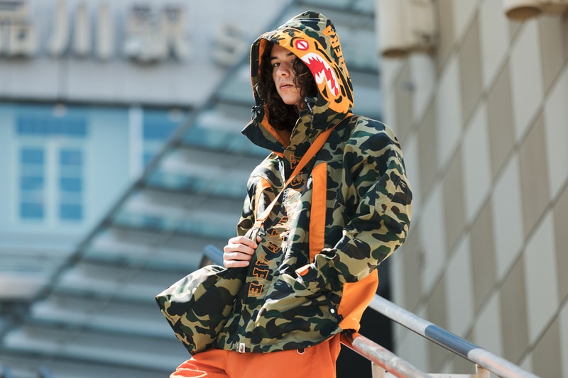BAPE®️ x PORTER STAND のコラボ企画 “TRUNK SHOW” の情報が解禁 BAPE® CAMO GREENと『PORTER STAND』のテーマカラーであるオレンジが融合した格別なアイテム全12型が登場 説明不要の世界的ストリートブランド〈A BATHING APE®（ア ベイシング エイプ）〉 の25周年と、世界中から愛され続けている吉田カバンのコンセプトショップ『PORTER STAND』の品川駅店オープン4周年を記念して、アニバーサリーコラボレーション企画“TRUNK SHOW”の開催が決定。BAPE® CAMO GREENと『PORTER STAND』のテーマカラーであるオレンジを貴重とした本コラボでは、スノーボードジャケット、MA-1、Tシャツ2種類に加え、Tシャツとショルダートートのセットやウエストバッグ、デイパック、ヘルメットバッグ、トラベルケース、サコッシュ、ミニウォレット、キーケースなど、〈PORTER（ポーター）〉の真髄であるラゲージ類も豊富に展開される。  互いのアイデンティティであるプロダクトを融合した格別な全12型のアイテムは、『PORTER STAND』の品川駅店および東京駅店において、第1弾が4月25日（水）、第2弾が5月19日（土）より先行発売開始。また、『BAPEXCLUSIVE™』の青山、京都、『BAPE STORE® DSM銀座』、そして、『BAPE.COM』では6月16日（土）より全アイテムを一斉リリースするようだ。アイテム一覧ならびに詳細は、こちらからご確認を。  無論、〈Anti Social Social Club（アンチ ソーシャル ソーシャル クラブ）〉x〈BAPE®️〉もお買い逃しのないように。