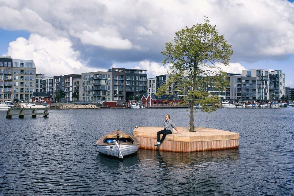小さな無人島が公共のスペースとして活用するコペンハーゲンの一風変わった取り組みをご紹介 ヨーロッパでも有数の観光地であるデンマークの首都コペンハーゲンにてユニークな試みがスタートしている。  その名も“Copenhagen Islands”は、誰もが自由に使える多目的なパブリックスペースとして小型の無人島をコペンハーゲン湾に浮かべるプロジェクトである。  オーストラリアの建築家、Marshall Blecher（マーシャル・ブレッヘル）とデンマークのデザインスタジオが共同で手掛けた20㎡の小さな人工の島は、ボート作りに使用される伝統的な技術を用いて、サスティナブルな地元の木材から制作されており、中央には1本のシナノキが植えられている。  現在、試験運用的にCPH-Ø1と名付けられた1つの島が浮かべられているが、カヤック乗りや遠泳中の人たちの休憩スポット、日光浴や釣り、小規模なイベントなどに利用されているという。将来的には、CPH-Ø2、Ø3と続く形で9つの島に拡大し、サウナや庭園をはじめ、ボートに乗りながらドライブスルーのように利用できるカフェを水上に展開する計画がある。また、浮遊するこれらの島々は移動させることが可能であり、複数集まることでその用途も多様化する。先行分のCPH-Ø1も今年いっぱいは季節毎にロケーションを変えながら運用される。  先述のように、この無人島は公共の場として自由に利用できるので、ヨーロッパを訪れる機会があれば、コペンハーゲン湾での水上BBQやキャンプを楽しんでみてはいかがだろうか。