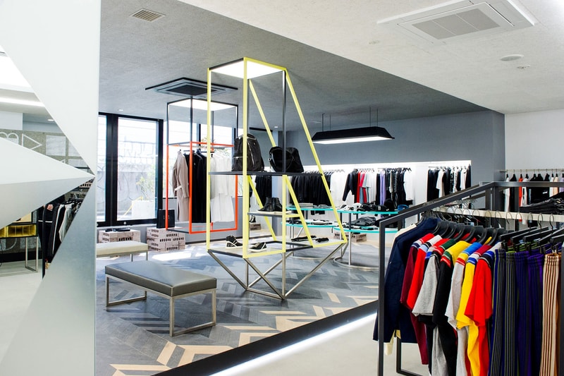 移転によりパワーアップを遂げた『NUBIAN HARAJUKU』の店内を初公開 旧店舗の約5倍にも拡大した新店舗はオンライン上にはないリアルな体験そのものをデザインした洗練された空間に ラグジュアリーストリートの代表格から高感度な国外のヘッズたちが目をつけ出しているアップカミングレーベルまで、“行き届いた”セレクトで信頼を集め、国内外から客足の絶えない『NUBIAN（ヌビアン）』が、原宿店を移転リニューアル。本稿では、一新された店内の様子を世界初公開しよう。  裏原宿から東郷神社の裏手、竹下通りの脇道へとスペースを移した『NUBIAN HARAJUKU』は、『TRUNK(STORE)』や『BEAMS JAPAN』を手がけた経歴を持つ「トラフ建築事務所」に内装協力を依頼し、敷地面積は旧店舗の約5倍に値する90平米にも拡大。左右非対称に広がるコの字型のスペースは、特定のブランドがイベント的に使うポップアップエリア、スケルトン天井の中央エリア、店内奥の高額商品を扱うエリアの3セクションに分割され、ひとつの大きな空間でありながら、高低差や内装材、照明などでエリア毎に個性を持たせている。また、色彩、形状豊かなプロダクトが雑然と見えないよう、店内には随所に幾何学的なインテリアが配置され、そのうちのいくつかはカラフルなフレームで『NUBIAN』の文字を模り、モノトーンな空間にプレイフルな要素をプラス。さらに、中央には純国産高級サウンドシステムを提供する「田口音響研究所」の技術が搭載されたウーファー内蔵のカウンターと高音質スピーカーが鎮座し、ポップアップやDJイベントなど、様々な使い方を許容する“余白”のあるスペースを目指したとのことだ。  オンラインが台頭する中、実店舗において商品と出会う体験そのものをデザインしたいと考えて設計された新生『NUBIAN HARAJUKU』。〈Maison Margiela（メゾン マルジェラ）〉や〈ACRONYM（アクロニウム）〉など、ハイエンドなブランドもストックされたことにより、セレクトショップとしての進化を感じさせるのみならず、今後はよりパワーアップしたプロジェクトが展開されることになるだろう。  『NUBIAN HARAJUKU』の店内の様子は、上の＠フォトギャラリーから。あわせて、『NUBIAN』の主要メンバーである若手敏腕バイヤー幅田将平のストリートスナップもプレイバックしてみてはいかがだろうか。