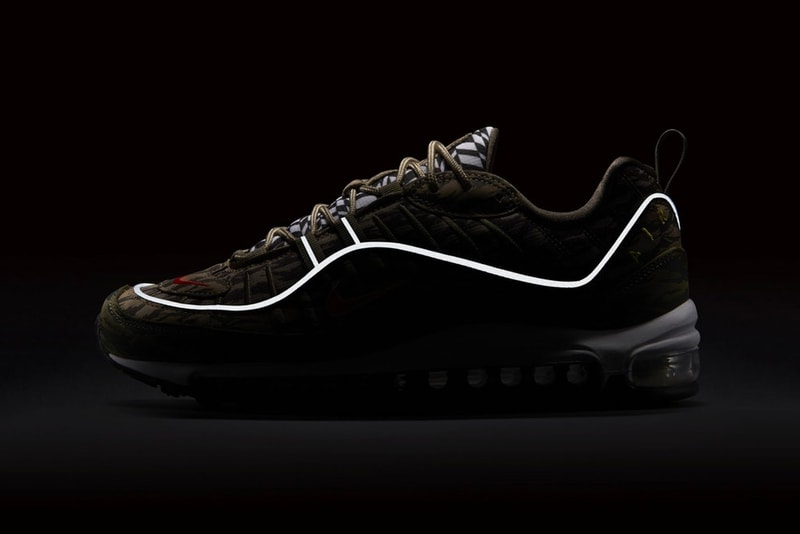 Nike より強烈な総柄プリントを採用した Air Max 98 “AOP” パックが登場 幾何学模様とカモ柄の個性豊かな2パターンがラインアップ スニーカーブームも一段落した90年代後半に登場したAir Max 98は、伝説のAir Max 95の生みの親、Sergio Lozano（セルジオ・ロザーノ）によって生み出されたシューズであるが、本モデルはそのアッパーのデザインや構成から、前年に発売された兄貴分のAir Max 97と比べるとカラフルで派手めの配色や素材を用いてリリースされる傾向にある。今回発表された“AOP(All-Over Print) ”パックでもその特徴が全面に出されている。  ブラック/ホワイトは〈ACRONYM®（アクロニウム）〉のAir VaporMax Moc 2にも通ずる幾何学模様が印象的であるが、ブラックのシュータンとマッドガードを装着することによって実際のデザイン以上に引き締まった印象を与える。一方、カモフラージュモデルは、部位によって異なるトーンのカモ柄がグラデーションのアッパーを構成。こちらのシュータンでも先述の幾何学模様が確認できる。両カラーウェイともにリフレクティブ素材のパイピングがあしらわれ、イエローで縁取りしたオレンジの小さなスウッシュを刺繍。そして、ソールはシンプルにホワイトのミッドソールに、当時の最先端テクノロジーであったフルレングスのMAX AIRが組み込まれ、アウトソールをブラックで仕上げている。  Air Max 98 “AOL”パックの発売日は5月31日（現地時間）、価格は160ドル（約176,00円）となる模様。上のフォトロールより各カラーウェイをチェックし、国内展開については〈Nike（ナイキ）〉からの続報を待とう。 HYPEBEAST