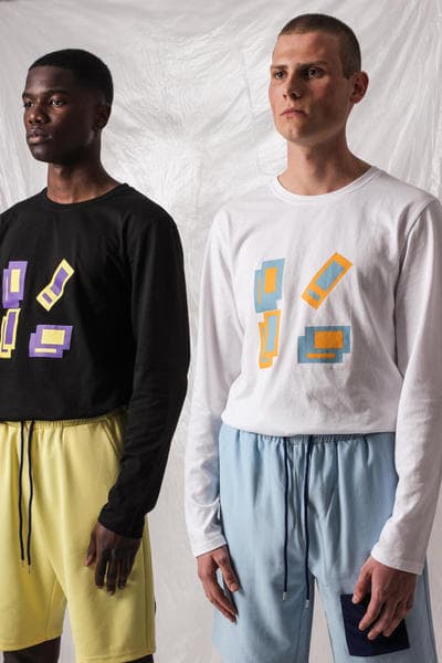 ガーナ発の L’ORIGINE よりシンプルな中にも強いメッセージ性を持った2018年夏コレクションが到着 肌の色の違うモデルや補色を使ったアイテムで人種や民族による隔たりのないオープンな社会を表現 2014年に設立されたガーナ発の新鋭ブランド〈L’ORIGINE（ロリジンヌ）〉が2017年秋冬コレクションに続き、クリーンさが際立つトップスやボトムスから小物類までを網羅した2018年サマーコレクションを発表。  二人のデザイナー、Dyllan Ahinful（ディラン・アヒンフル）とJeffrey Mensah（ジェフリー・メンサー）が率いる同ブランドであるが、今季は“Opposites Attract And Enhance”をテーマとして相違点にフォーカス。肌の色の違う二人のモデルを起用し、補色（互いの色を最も目立たせる色の組み合わせ）を強調することで、性質の異なるものが一緒になり生まれる相乗効果を表わしている。また、カラースキームにおいては、Claude Monet（クロード・モネ）らに代表される印象派にインスパイアされており、パステルブルーとイエローを基調としたアイテムが全ルックに登場、ミニマルな装飾が施されたポロシャツからショーツ、トラックスーツまでが並ぶ。その他にはストライプ柄のシャツや、ベーシックなブラックとホワイトをベースにブランドロゴなどのグラフィックがプリントされたフーディーやナイロン素材のアノラック、ボディバッグやサンダルがラインアップ。  今サマーコレクションは、〈L’ORIGINE〉の公式サイトにて一部のアイテムのプレオーダーを開始している。まずは上のフォトロールより、デザイナーのメッセージが詰まった各ルックをチェックしてみよう。