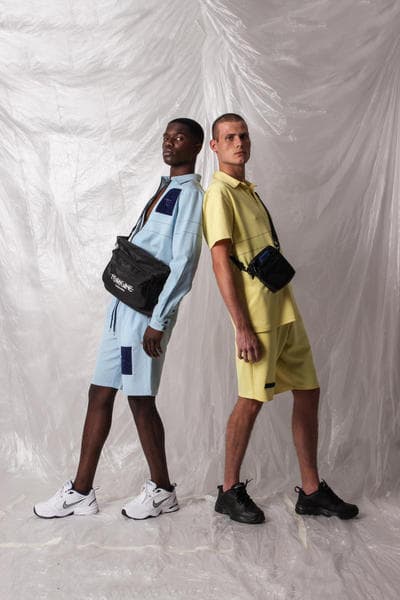 ガーナ発の L’ORIGINE よりシンプルな中にも強いメッセージ性を持った2018年夏コレクションが到着 肌の色の違うモデルや補色を使ったアイテムで人種や民族による隔たりのないオープンな社会を表現 2014年に設立されたガーナ発の新鋭ブランド〈L’ORIGINE（ロリジンヌ）〉が2017年秋冬コレクションに続き、クリーンさが際立つトップスやボトムスから小物類までを網羅した2018年サマーコレクションを発表。  二人のデザイナー、Dyllan Ahinful（ディラン・アヒンフル）とJeffrey Mensah（ジェフリー・メンサー）が率いる同ブランドであるが、今季は“Opposites Attract And Enhance”をテーマとして相違点にフォーカス。肌の色の違う二人のモデルを起用し、補色（互いの色を最も目立たせる色の組み合わせ）を強調することで、性質の異なるものが一緒になり生まれる相乗効果を表わしている。また、カラースキームにおいては、Claude Monet（クロード・モネ）らに代表される印象派にインスパイアされており、パステルブルーとイエローを基調としたアイテムが全ルックに登場、ミニマルな装飾が施されたポロシャツからショーツ、トラックスーツまでが並ぶ。その他にはストライプ柄のシャツや、ベーシックなブラックとホワイトをベースにブランドロゴなどのグラフィックがプリントされたフーディーやナイロン素材のアノラック、ボディバッグやサンダルがラインアップ。  今サマーコレクションは、〈L’ORIGINE〉の公式サイトにて一部のアイテムのプレオーダーを開始している。まずは上のフォトロールより、デザイナーのメッセージが詰まった各ルックをチェックしてみよう。